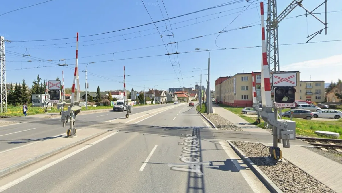 Zabezpečené železničné priecestie so závorami a výstražnými svetlami